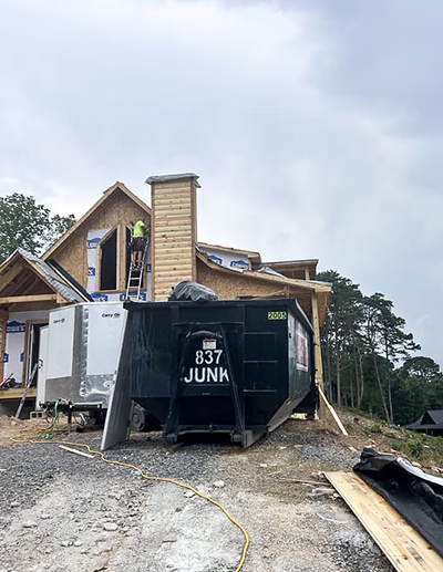 837JUNK roll-off dumpster at a residential construction site