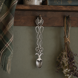 Pewter lovespoon hanging on a wood sideboard