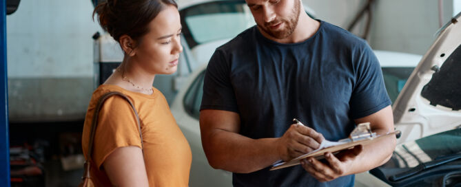 Woman talking to auto body estimator about insurance claim