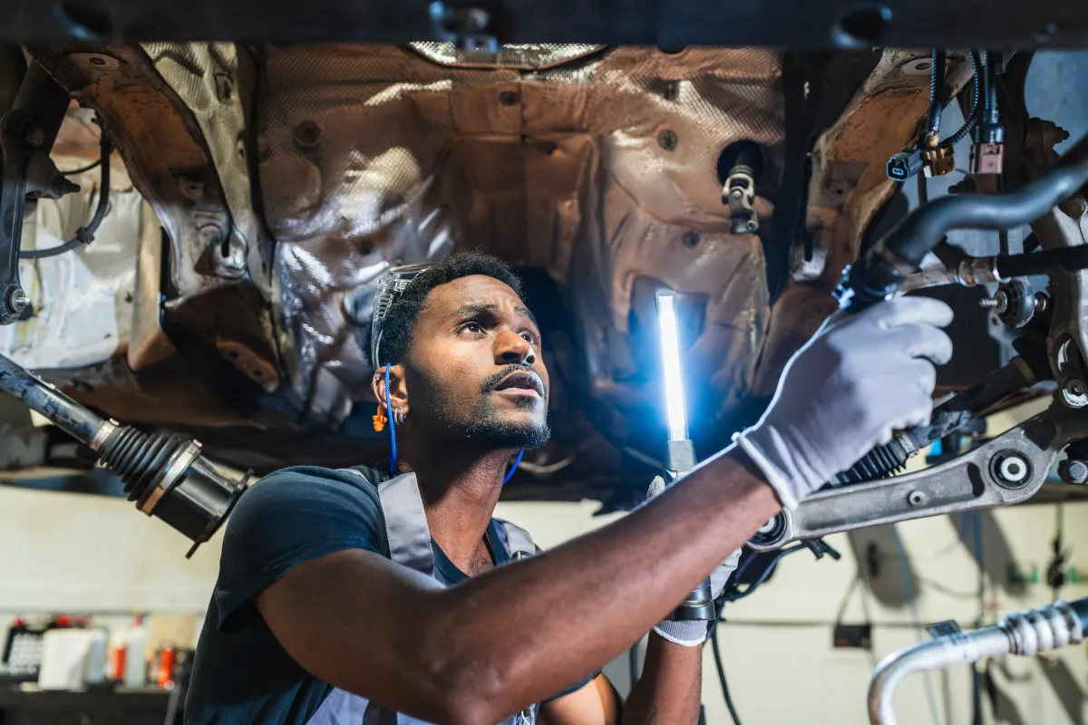 Mechanic inspecting car chassis
