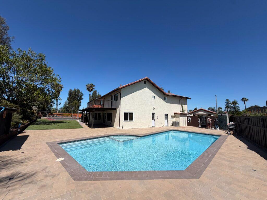Rectangular pool with tiled edging and a paved surround