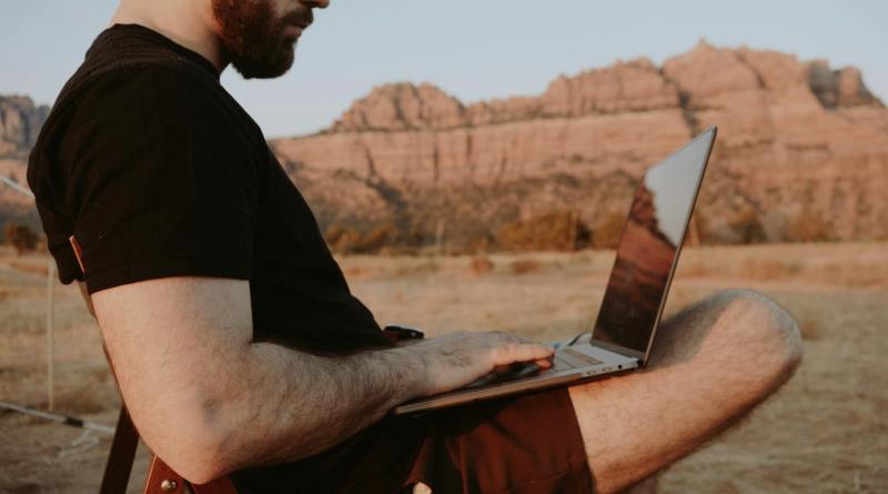 Thoughtful remote worker with laptop in countryside