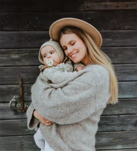 A young mother holding her child after choosing parenting with local support