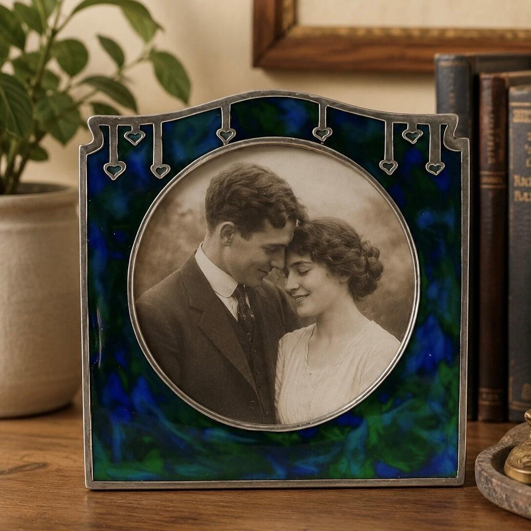 Art Nouveau pewter picture frame with arched top, heart motifs and blue-green enamel