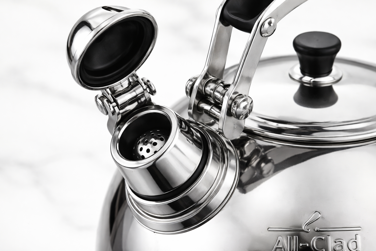 Close up of All Clad tea kettle whistle mechanism and hinged cap opening