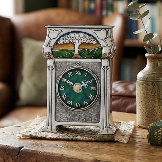 Arts and Crafts style pewter mantel clock designed by Archibald Knox with green and blue enamelled face