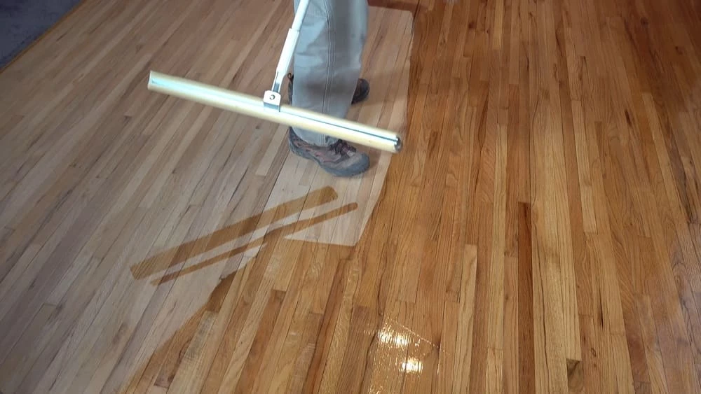 Man adding a finish to unfinished floors